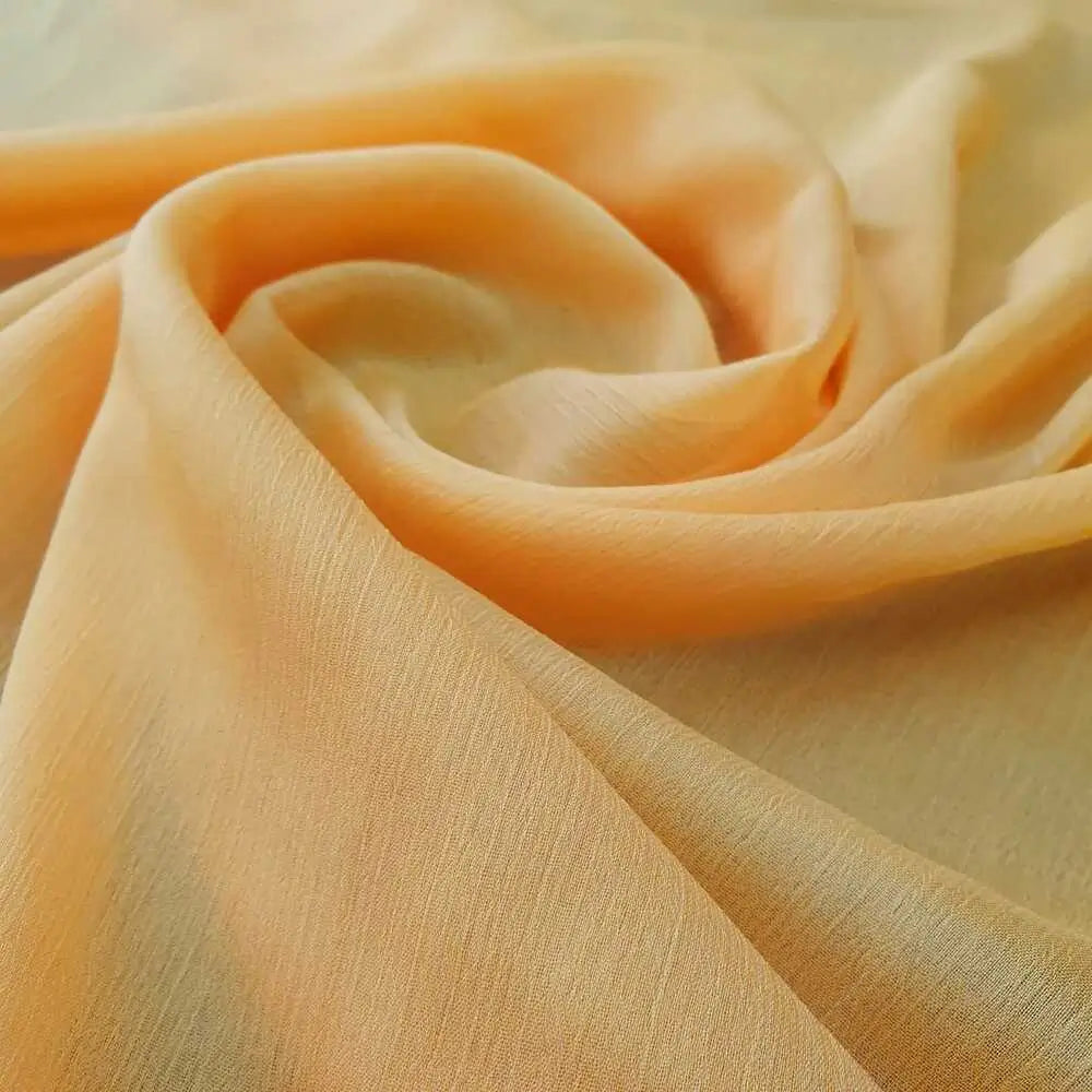 Chiffon musseline na cor amarelo-ouro, translúcido e de caimento leve.