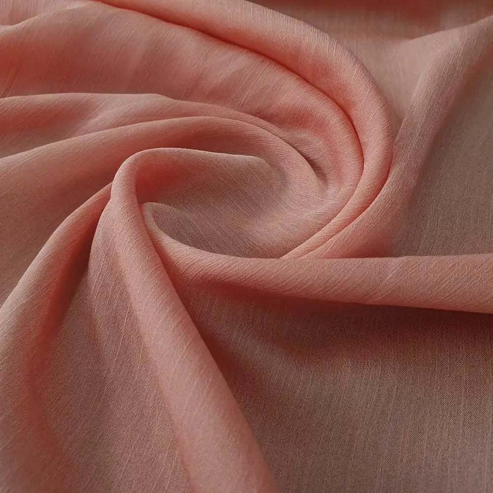Tecido chiffon musseline liso na cor goiaba, fino e com ótimo drapeado.