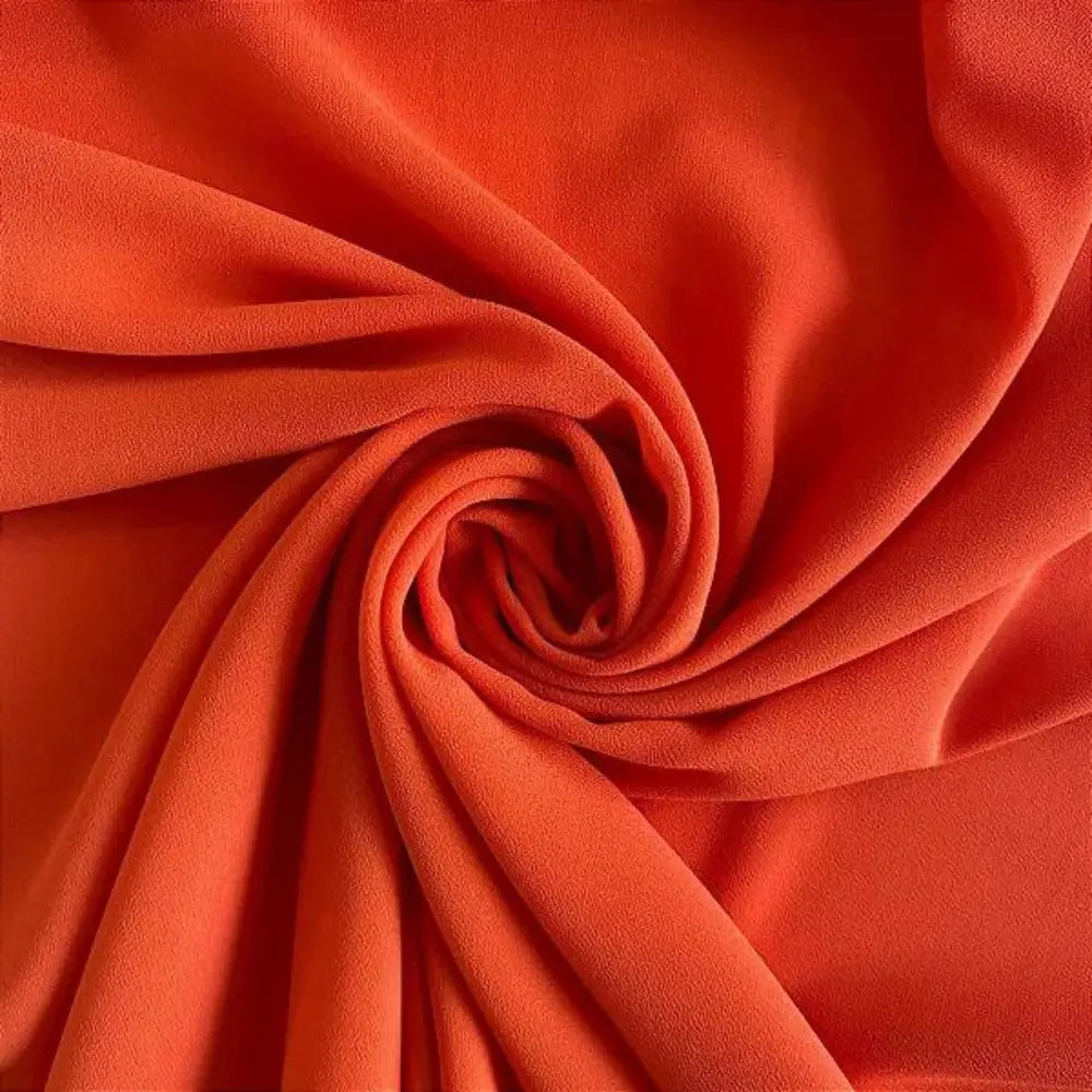 Tecido crepe hi-twist laranja queimado com acabamento acetinado e dobras volumosas.