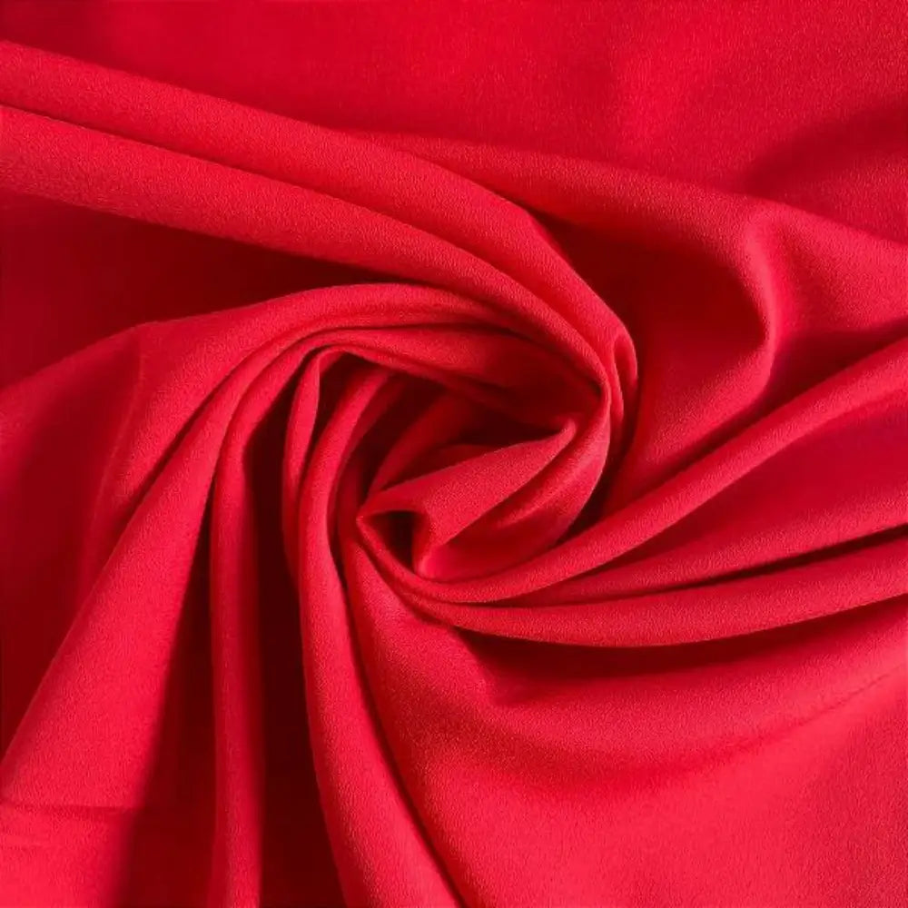 Tecido crepe hi-twist vermelho rubi com textura rica e padrão espiral marcante.
