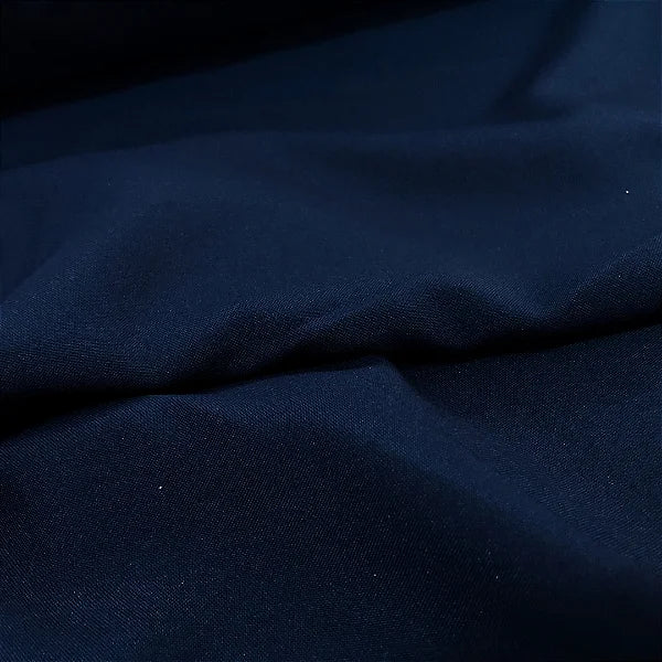 Close-up de tecido oxfordine na cor azul marinho, com superfície texturizada e aspecto encorpado.