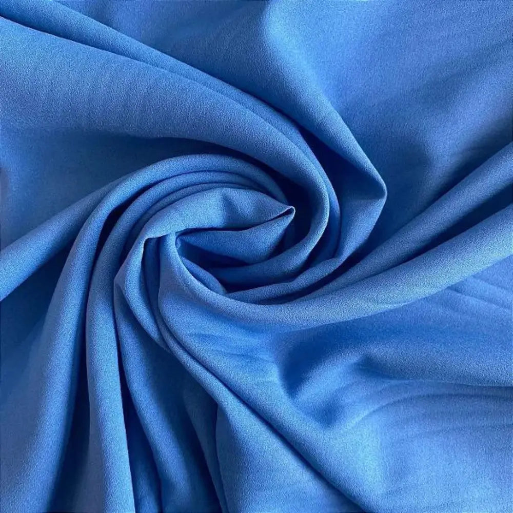 Tecido crepe hi-twist azul, com sombras suaves e dobras fluidas.