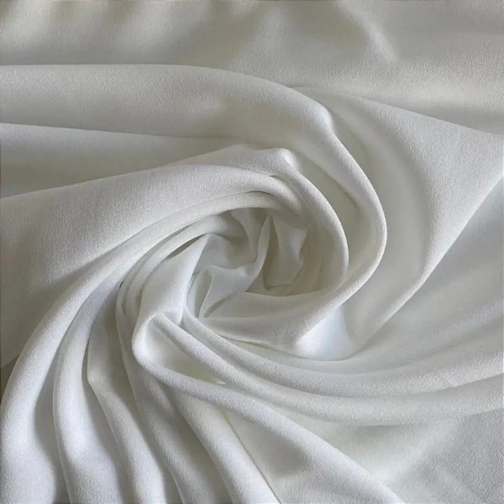 Tecido crepe hi-twist branco com detalhes de textura granulada e torção suave.