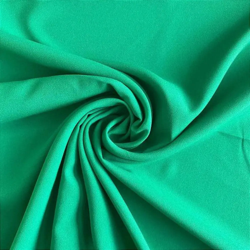 Tecido crepe hi-twist verde vibrante com acabamento brilhante e dobras dramáticas.