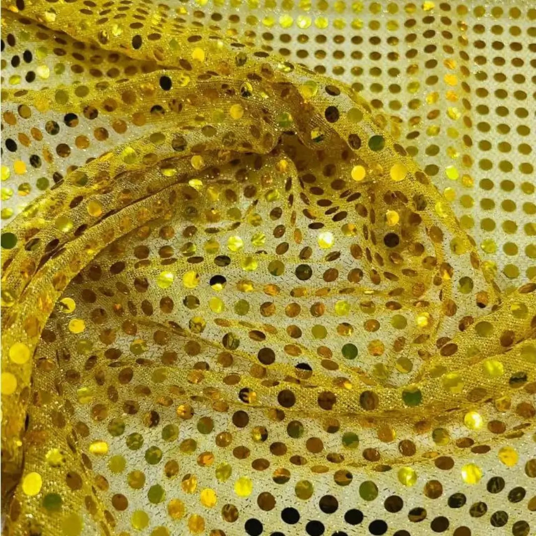 Tecido amarelo vibrante com lantejoulas que refletem luz, oferecendo um aspecto dourado e festivo.