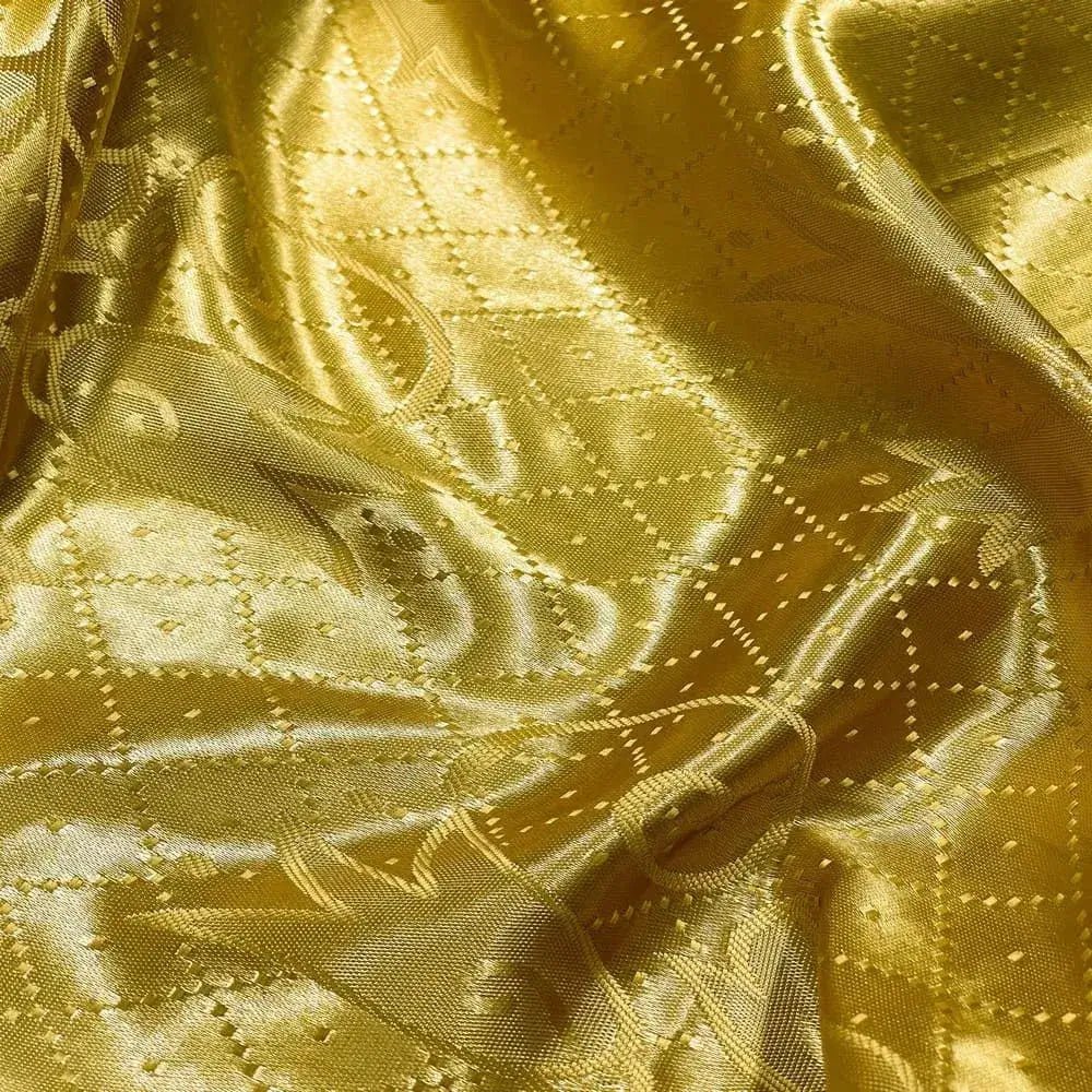 Tecido satin jacquard com tonalidade amarelo ouro brilhante, apresentando um padrão pontilhado e linhas onduladas.