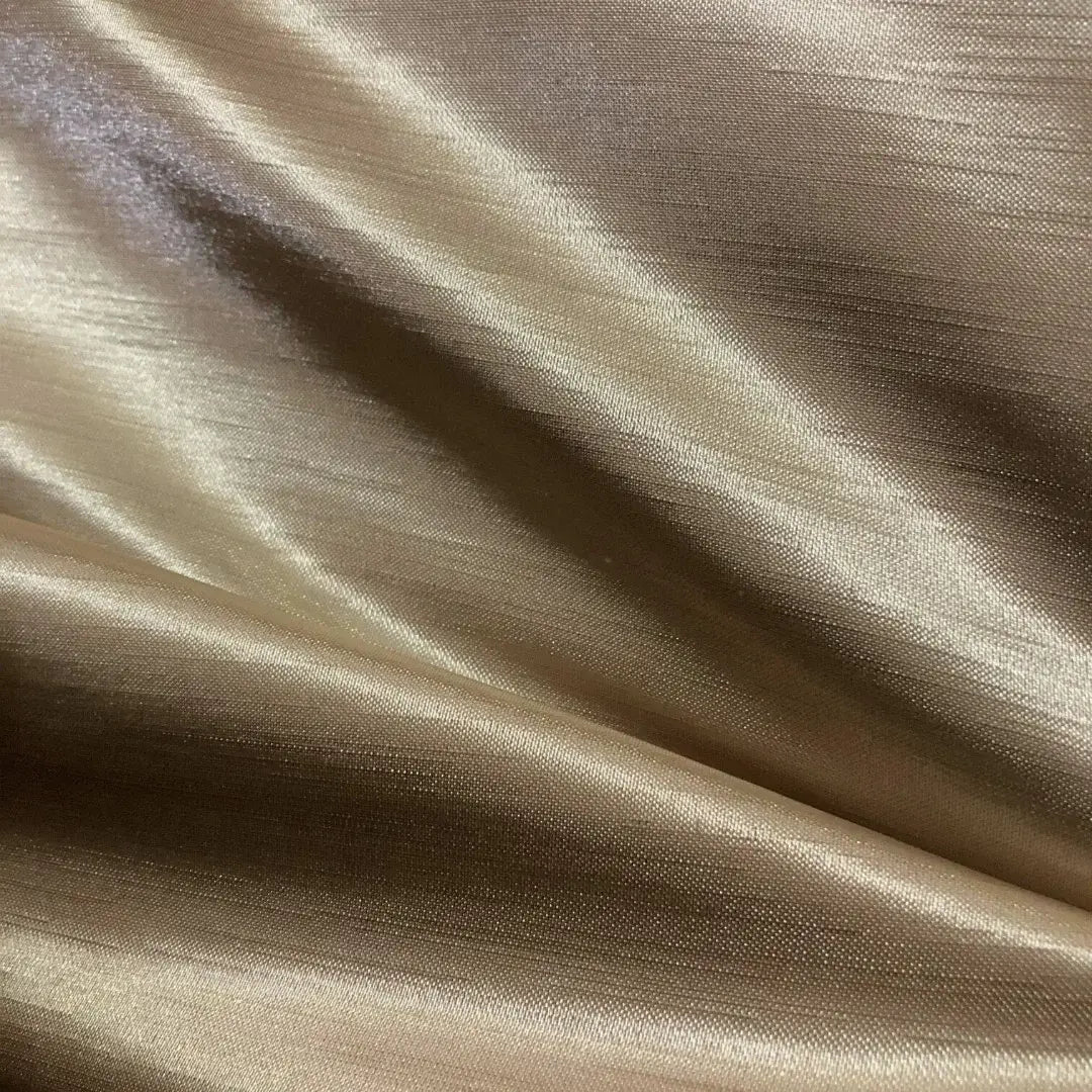 Tecido shantung dourado com reflexos metálicos e acabamento refinado, luxuoso para decoração.