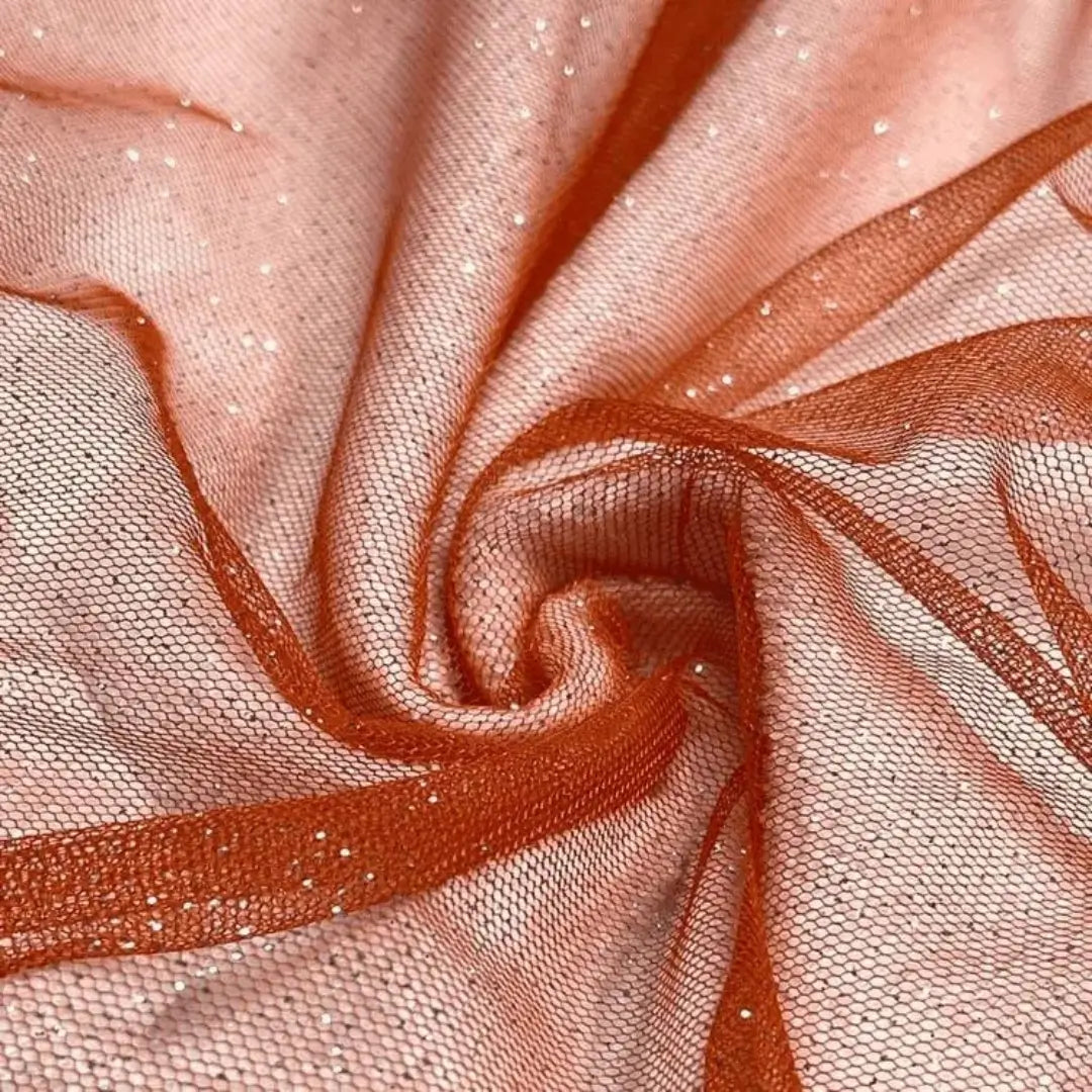 Tule na cor coral com glitter, ideal para criar peças vibrantes com um acabamento luminoso.